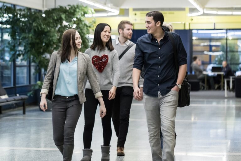 Opiskelijoita kävelemässä yliopiston käytävällä